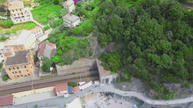 La Spezia, İtalya 'daki Cinque Terre' nin Monterosso al Mare köyünün panorama manzarası. Drone demiryolu, sahil ve köyden yükseliyor. Eski İtalyan köyü ve güzel körfezin mimarisi. Video 4K