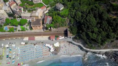 La Spezia, İtalya 'daki Cinque Terre' nin Monterosso al Mare köyünün panorama manzarası. Tren yolu, sahil ve köyün panoramik insansız hava aracı manzarası. Eski İtalyan köyünün mimarisi ve güzel bay.Video 4K