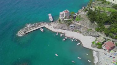Monterosso, Liguria bölgesinin bir parçası olan La Spezia ilindeki bir köydür. Eski italyan köyünün mimarisi ve güzel sahil manzarası. İnsansız hava aracı yarımadaya, plaja ve botlara iniyor.