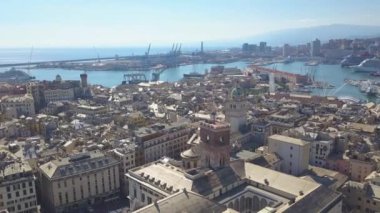 Aerial panoramic drone view of buildings and streets surrounding Port of Genoa.Old famous city of Italy, with beautiful architecture, houses, roofs, buildings.Cruise ships and ferries in port.4K video