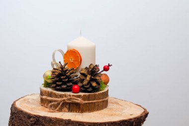 Çam kozalakları, mumlar ve kurutulmuş meyvelerle Noel süslemesi.