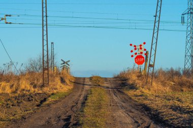 Dur işaretiyle biten çamurlu toprak bir yol.