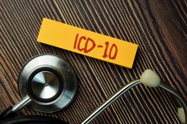 ICD - 10 yapışkan nota ve steteskop Tahta Masa 'ya izole edilmiş. Tıbbi Konsept