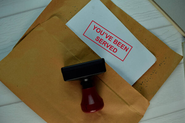 Red Handle Rubber Stamper and You've Been Served text isolated on the table.