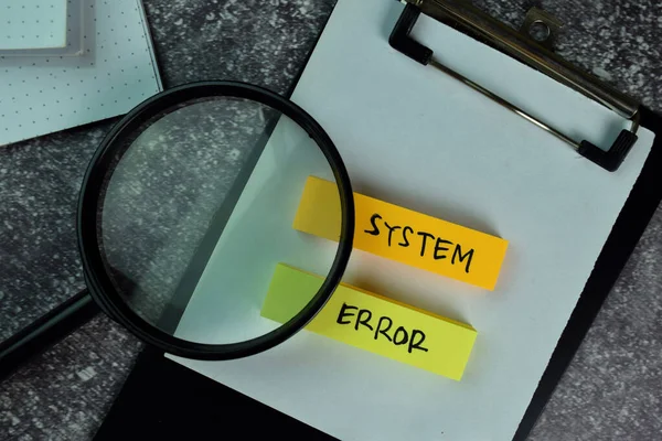 System Error write on sticky notes on the table.
