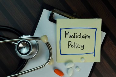 Mediclaim Politikası, Tahta Masa 'ya izole edilmiş yapışkan notların üzerine yazıyor. Tıbbi ya da Sağlık Konsepti