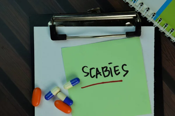 Scabies Γράφουν Αυτοκόλλητες Σημειώσεις Που Απομονώνονται Στο Ξύλινο Τραπέζι Ιατρική — Φωτογραφία Αρχείου