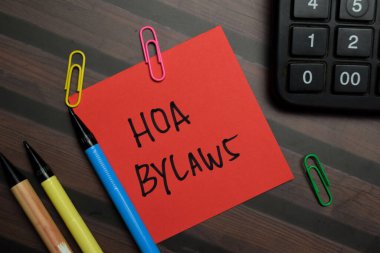 HOA Bylaws write on sticky notes isolated on Wooden Table. clipart