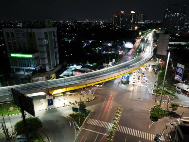 Hava görüntüsü. Gece otoyolda hafif patikalar, Bekasi 'de uzun süre soyut kentsel arka plan ve gürültü bulutu. BEKASI, İNDONEZYA - 27 HAZİRAN, 2021