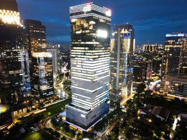 Jakarta merkez iş bölgesindeki ofis binalarının hava manzarası ve gün batımında gürültü bulutu. JAKARTA, İNDONEZYA - 27 OCAK, 2021