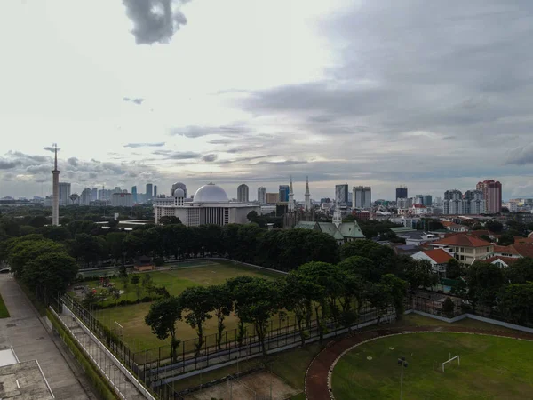 ジャカルタ大聖堂とイスティカルモスクの空中ビュー 東南アジア最大のモスクであり ジャカルタの街並みを持つ騒音雲です ジャカルタ インドネシア 2021年1月30日 — ストック写真