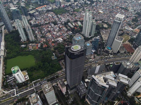 Aerial view of highway intersection and buildings in the city of Jakarta and noise cloud with Jakarta cityscape. JAKARTA - Indonesia. February 11, 2021