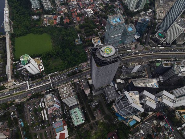 Aerial view of highway intersection and buildings in the city of Jakarta and noise cloud with Jakarta cityscape. JAKARTA - Indonesia. February 11, 2021