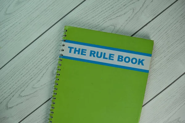 The book about The Rule Book isolated on wooden table.