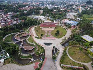 Çevresi yeşil ağaçlarla çevrili parktaki bahçe aktivitelerinde renkli çocukların oyun parkının havadan görünüşü. Şehir çocukluk konsepti. DEPOK, İNDONEZYA - 25 Mart 2021