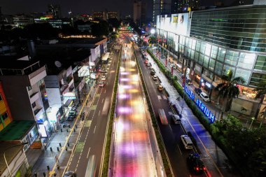 Senen 'deki şehir trafiğinin hava görüntüsü geceleri kesişiyor. Araçlar binalar arasındaki yolda ilerliyor. Jakarta, Endonezya, 28 Nisan 2021