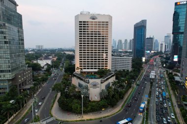 Otel Endonezya Kavşağı 'ndaki şehir trafiğinin hava görüntüsü. Araçlar binalar arasındaki yolda ilerliyor. Jakarta, Endonezya, 28 Nisan 2021