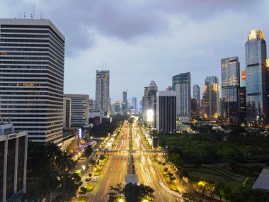 Gece Jakarta 'daki şehir trafiğinin hava görüntüsü. Araçlar binalar arasındaki yolda ilerliyor. Yollara odaklan. Jakarta, Endonezya, 6 Mayıs 2021