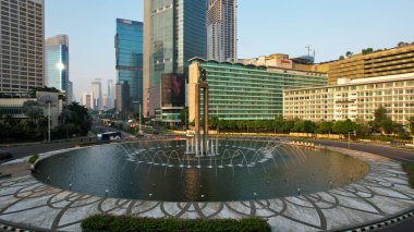 Otel Endonezya Kavşağı 'ndaki şehir trafiğinin hava görüntüsü. Araçlar binalar arasındaki yolda ilerliyor. Jakarta, Endonezya, 13 Mayıs 2021