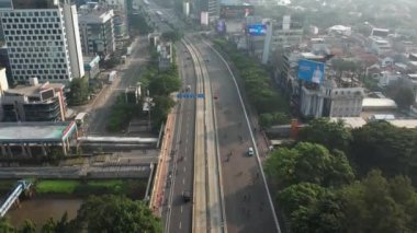 Anayolda, motosiklette ve arabada bisiklet süren bisikletli grubun hava görüntüsü. Dron manzaralı bisiklet kırsal yolda araba yolunda. JAKARTA - Endonezya. 21 Mayıs 2021 