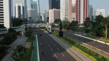 Anayolda, motosiklette ve arabada bisiklet süren bisikletli grubun hava görüntüsü. Dron manzaralı bisiklet kırsal yolda araba yolunda. JAKARTA - Endonezya. 21 Mayıs 2021 
