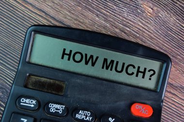 How Much write on calculator isolated on Wooden Table.