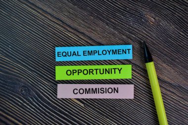 Equal Employment Opportunity Commision write on sticky notes isolated on Wooden Table.