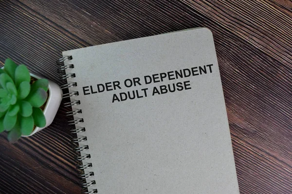 The book of Elder or Dependent Adult Abuse isolated on Wooden Table.