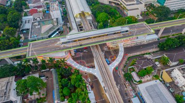 Kebayoran Baru 'daki ana tren istasyonu MRT hattının yakınındaki otobüs durağına gelen ve giden eklemli şehir otobüslerinin hava görüntüsü. Jakarta, Endonezya, 29 Temmuz 2021