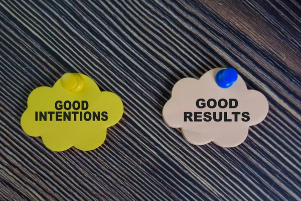 Good Intentions or Good Results write on sticky notes isolated on Wooden Table.