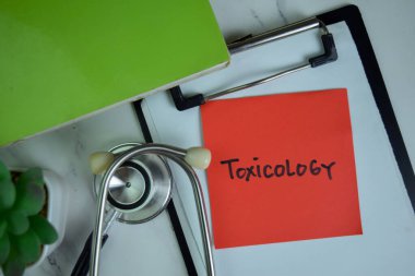 Tahta Masa 'da izole edilmiş yapışkan notlar üzerine toksikoloji yazısı.