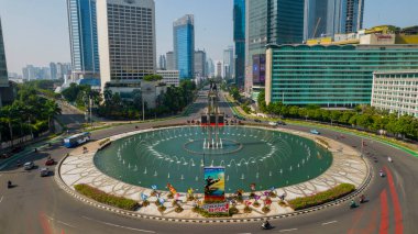 Otel Endonezya Kavşağı 'ndaki şehir trafiğinin hava görüntüsü. Araçlar binalar arasındaki yolda ilerliyor. Jakarta, Endonezya, 5 Eylül 2021