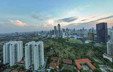 Asya 'nın gayrimenkul ticareti konsepti - panoramik modern şehir manzarası günbatımının altında kuş bakışı manzara ve Jakarta' da mavi parlak gökyüzü. Jakarta, Endonezya, 23 Eylül 2021