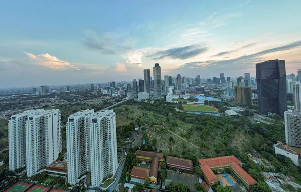 Asya 'nın gayrimenkul ticareti konsepti - panoramik modern şehir manzarası günbatımının altında kuş bakışı manzara ve Jakarta' da mavi parlak gökyüzü. Jakarta, Endonezya, 23 Eylül 2021