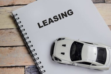 Tahta Masa 'da izole edilmiş anahtar sözcüklerle kitap üzerine yazılmış bir araba kiralama kavramı.