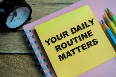 Günlük rutininizin kavramı Tahta Masa 'ya izole edilmiş yapışkan notlara yazılır.