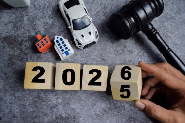 Yeni yılın kutlu olsun. Evin, araban ve tokmak adaleti masanın üzerinde tahta küplerle. Araba hukuku, ev sigortası ve emlak vergisi kavramı