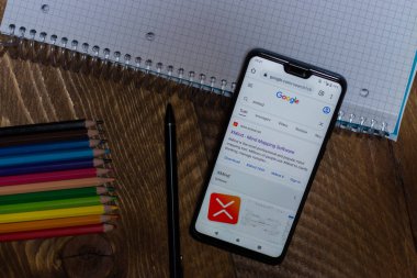 Benevento - 29 Kasım 2020: Xmind Harita web sitesi sayfası ahşap arka planda siyah bir cep telefonu görüntüsü. Logo simgesi. İllüstrasyon Editörü. Arka planda renkli boya kalemleri, kapasite kalem ve kare bir defter var..