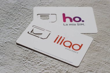 Benevento, İtalya - 5 Aralık 2020: Ho.mobile operatörünün Sim 'i. Vodafone ağındaki düşük maliyetli operatör ve Fransız operatör İlyada. Arka planda cep telefonu uygulamalı akıllı telefon..