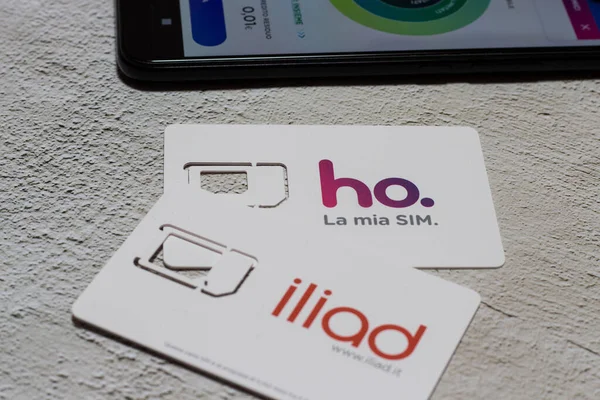 Benevento, İtalya - 5 Aralık 2020: Ho.mobile operatörünün Sim 'i. Vodafone ağındaki düşük maliyetli operatör ve Fransız operatör İlyada. Arka planda cep telefonu uygulamalı akıllı telefon..