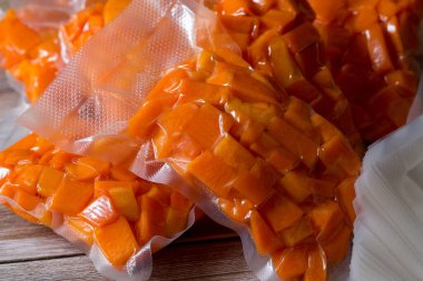 Sarı balkabağı dilimlere, küplere ve vakum paketlerine ayrılmış.