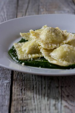 Patates ve havuçla doldurulmuş Ravioli. Borage püresinin üzerinde. Parmesan peyniri ve karabiber serpiştirilmiş.