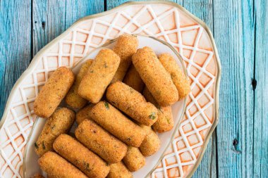 Servis tabağında servis edilen vejetaryen patates kroketleri.