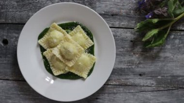 Patates ve havuçla doldurulmuş Ravioli. Borage püresinin üzerinde. Parmesan peyniri ve karabiber serpiştirilmiş.