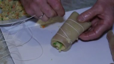Doldurulmuş domuz derisi hazırlayan yaşlı kadının elleri. Eski köylü geleneğinin tabağı..