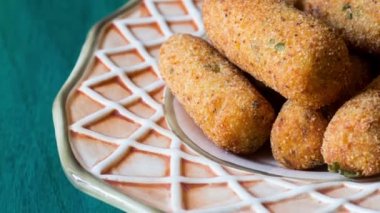 Servis tabağında servis edilen vejetaryen patates kroketleri.