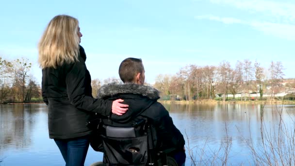 Pojęcie Osoby Niepełnosprawnej Mężczyzna Wózku Inwalidzkim Zewnątrz Naturze Przed Jeziorem — Wideo stockowe