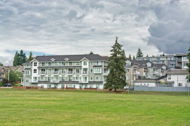 Önünde kocaman yeşil çimenler olan yeni bir apartman binası.