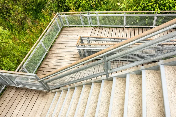 Лестница и деревянная палуба с металлическими рельсами в парке — стоковое фото