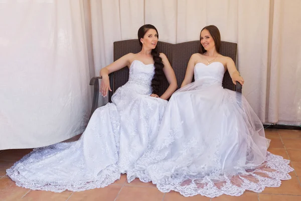 Two beautiful brides posing in sofa — Stock Photo, Image